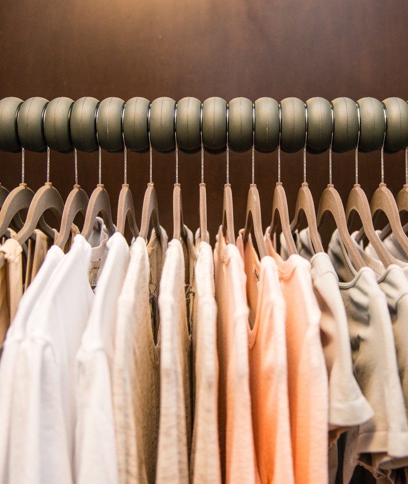 Foto de armario vestidor de mujer minimalista pequeño con armarios con paneles lisos y puertas de armario de madera en tonos medios