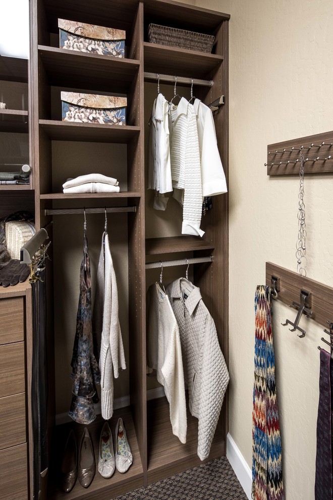 Inspiration for a small contemporary gender-neutral carpeted reach-in closet remodel in San Francisco with glass-front cabinets and medium tone wood cabinets