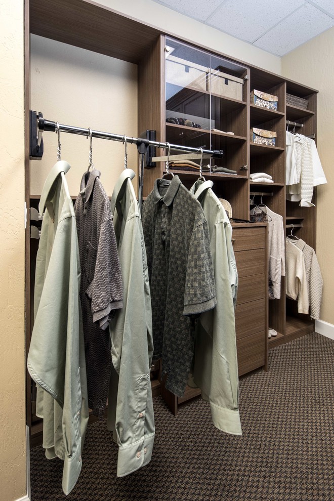 Design ideas for a small contemporary gender neutral standard wardrobe in San Francisco with glass-front cabinets, medium wood cabinets and carpet.