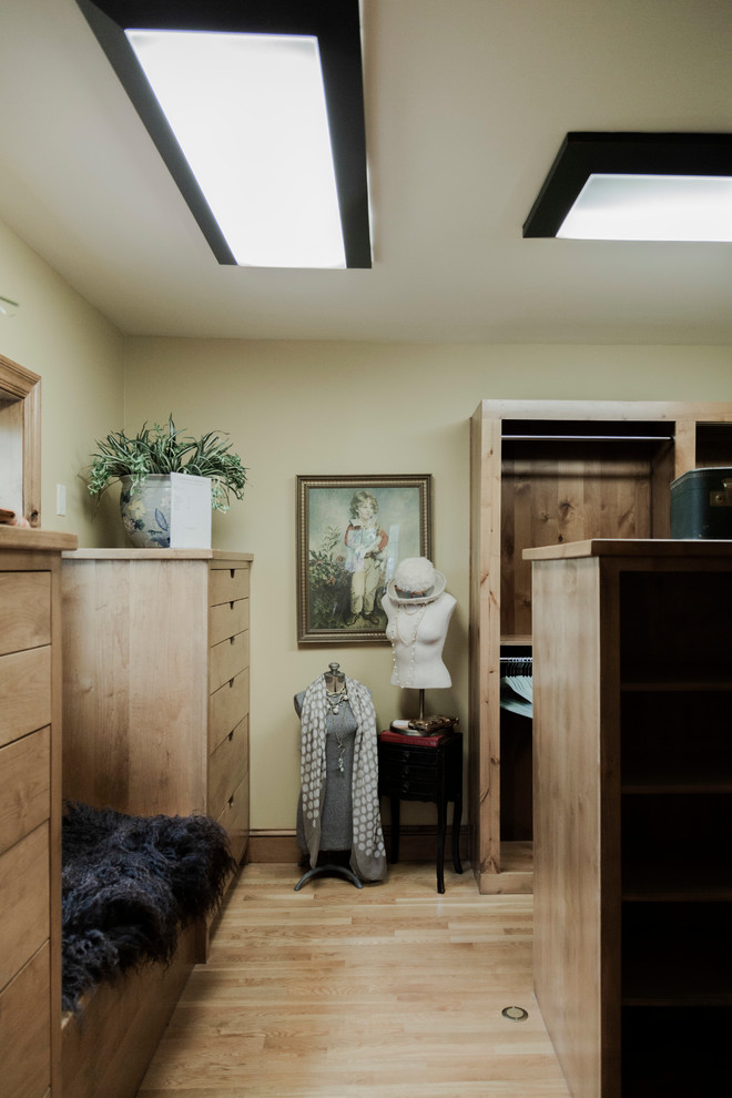Diseño de armario vestidor unisex ecléctico grande con armarios con paneles lisos, puertas de armario de madera oscura, suelo de madera en tonos medios y suelo marrón