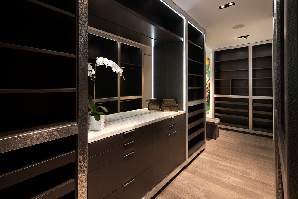 Идея дизайна: большая гардеробная комната унисекс в современном стиле с плоскими фасадами, темными деревянными фасадами, светлым паркетным полом и коричневым полом