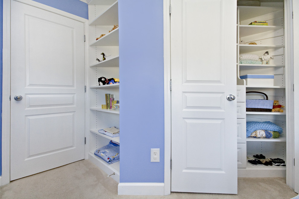 Cette photo montre un placard dressing chic de taille moyenne pour un homme avec un placard avec porte à panneau surélevé, des portes de placard blanches, moquette et un sol beige.