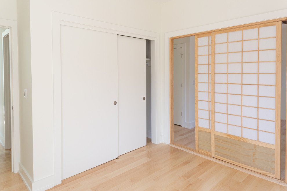 На фото: шкаф в нише среднего размера, унисекс в стиле модернизм с плоскими фасадами, светлым паркетным полом и коричневым полом с