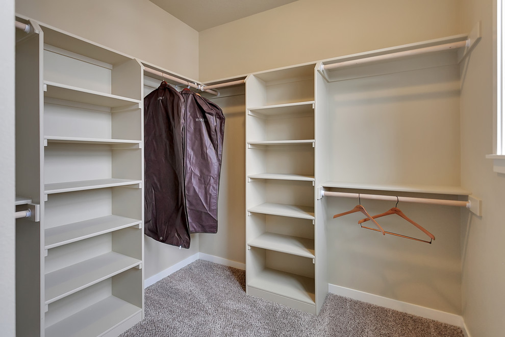 Inspiration for a medium sized classic gender neutral walk-in wardrobe in Portland with beige cabinets and carpet.