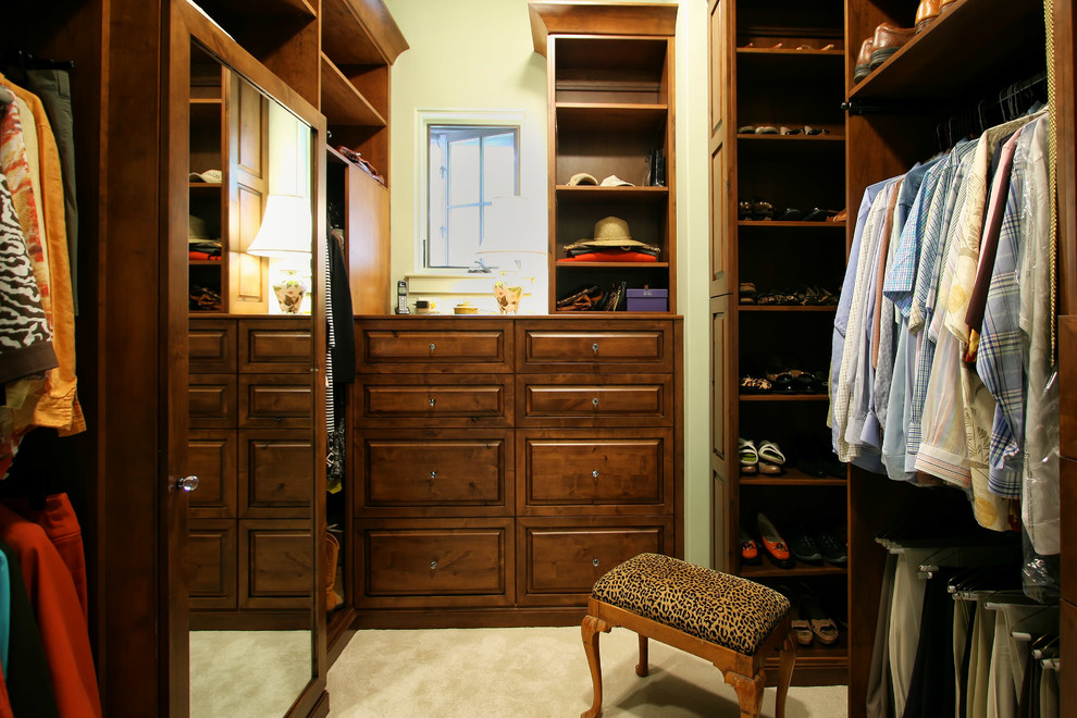 Walk-in closet - rustic gender-neutral carpeted walk-in closet idea in Charlotte with raised-panel cabinets and medium tone wood cabinets