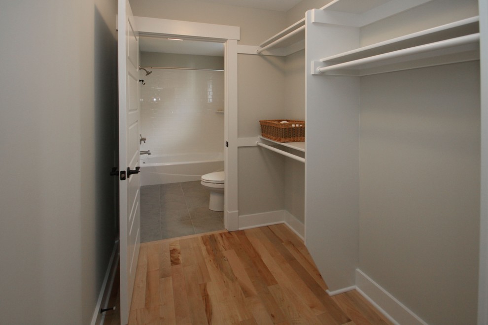 Inspiration for a classic wardrobe in Indianapolis with light hardwood flooring.