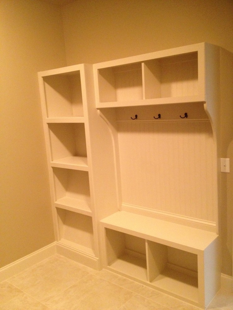 This is an example of a large classic gender neutral walk-in wardrobe in Other with white cabinets.