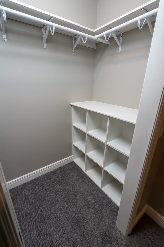 Modern inredning av ett mellanstort walk-in-closet för könsneutrala, med öppna hyllor, vita skåp, heltäckningsmatta och grått golv