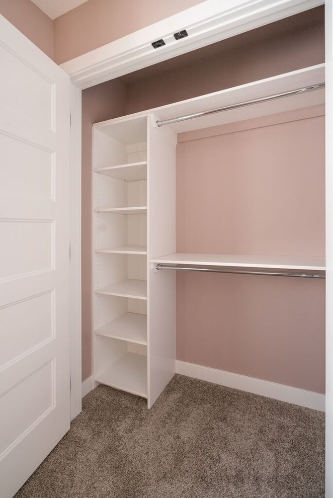 Immagine di un piccolo armadio o armadio a muro unisex american style con moquette e pavimento grigio