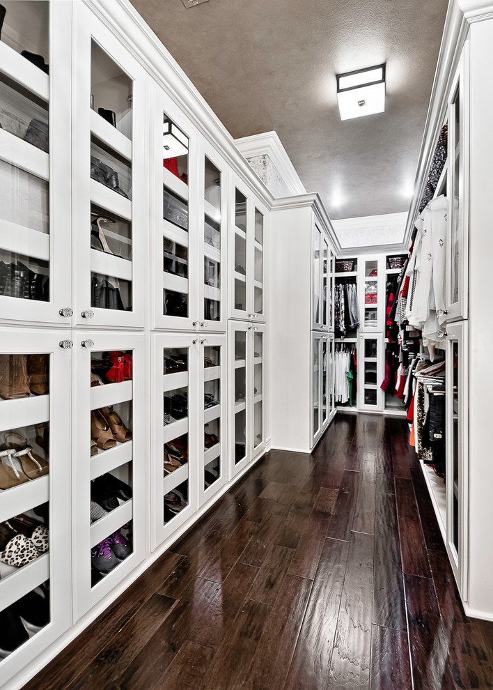 Photo of a large classic walk-in wardrobe for women in Other with raised-panel cabinets, white cabinets, dark hardwood flooring and brown floors.
