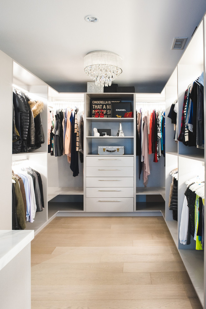 Design ideas for a large contemporary gender neutral dressing room in Vancouver with open cabinets, white cabinets, light hardwood flooring and brown floors.