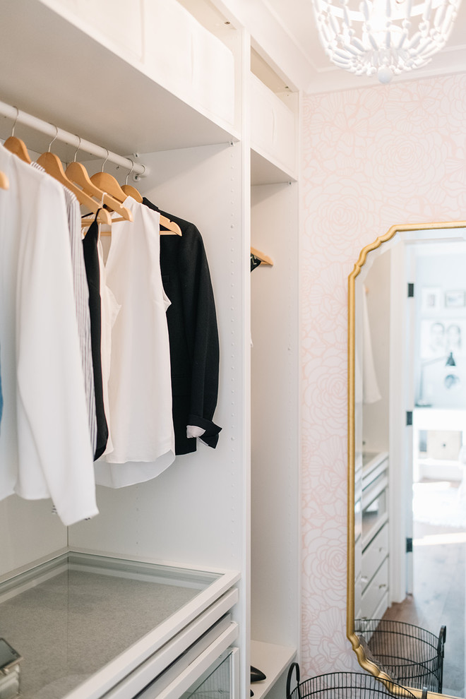 Foto de armario vestidor de mujer ecléctico pequeño con armarios abiertos, puertas de armario blancas, suelo de madera en tonos medios y suelo marrón