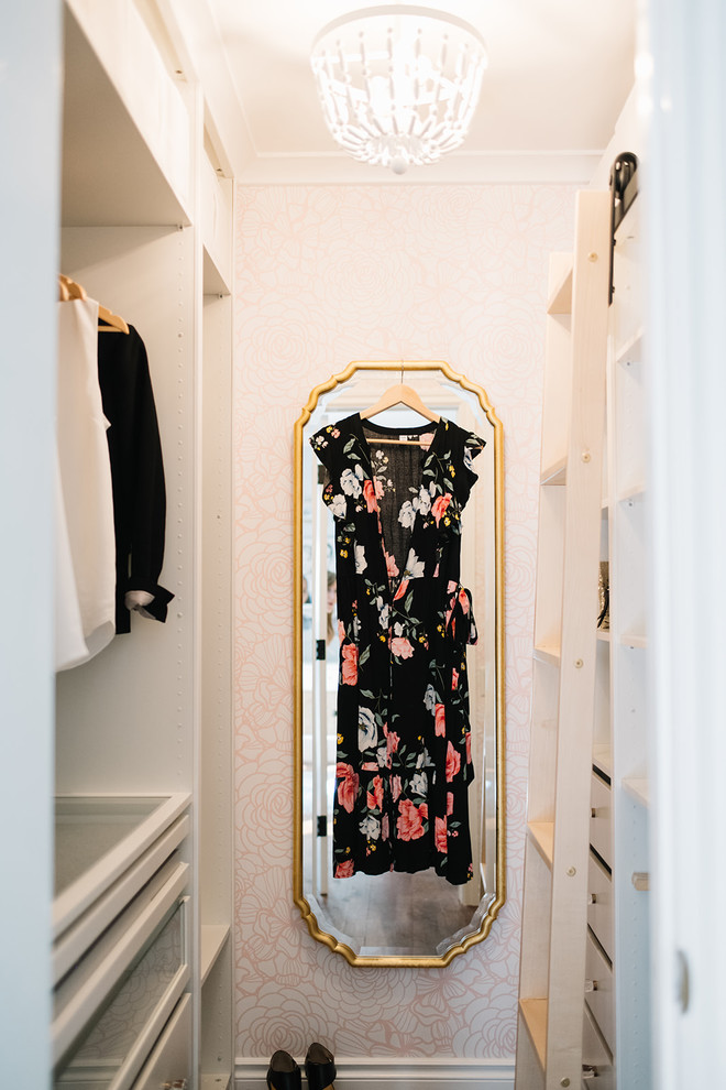 Foto de armario vestidor de mujer ecléctico pequeño con armarios abiertos, puertas de armario blancas, suelo de madera en tonos medios y suelo marrón
