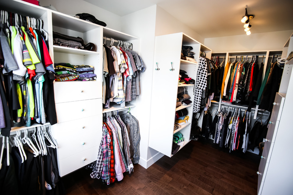 Medium sized country gender neutral walk-in wardrobe in Montreal with flat-panel cabinets, white cabinets and dark hardwood flooring.