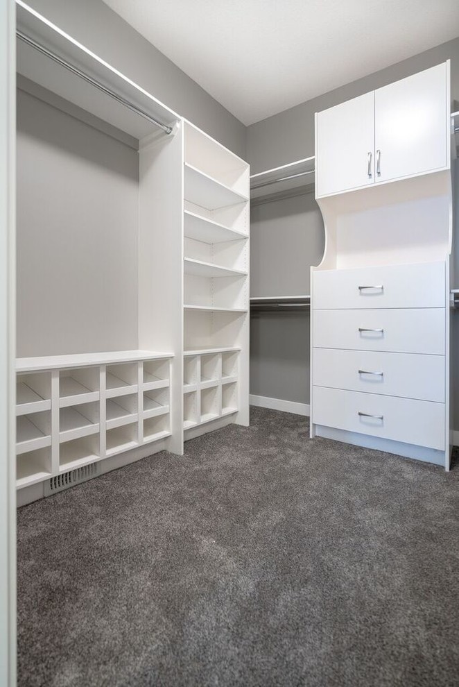 Ejemplo de armario vestidor unisex de estilo americano grande con armarios con paneles lisos, puertas de armario blancas, moqueta y suelo beige
