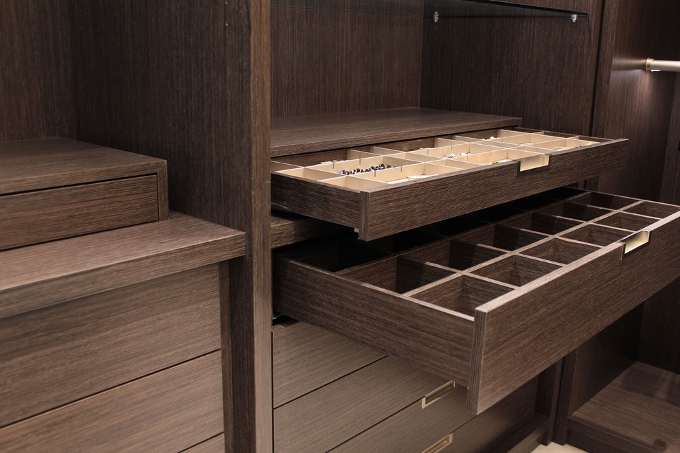 Ejemplo de armario vestidor minimalista con armarios con paneles lisos, puertas de armario de madera en tonos medios, suelo de madera clara y suelo beige