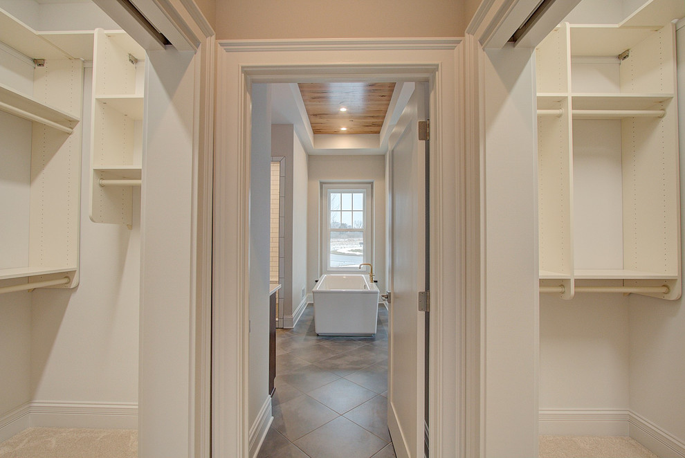 На фото: гардеробная комната среднего размера, унисекс в стиле неоклассика (современная классика) с открытыми фасадами, белыми фасадами, ковровым покрытием и серым полом