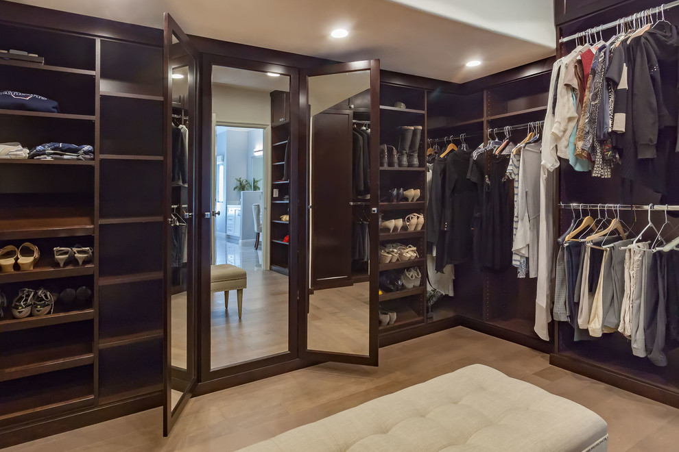 Imagen de armario vestidor unisex minimalista grande con armarios estilo shaker, puertas de armario de madera en tonos medios y suelo de madera clara