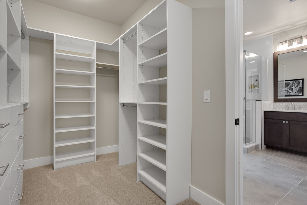 Photo of a medium sized classic gender neutral walk-in wardrobe in Seattle with flat-panel cabinets, white cabinets, carpet and grey floors.
