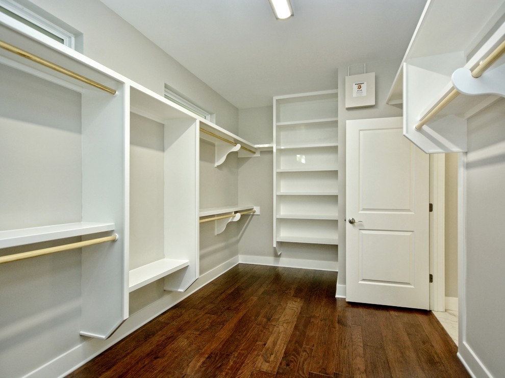 Ejemplo de armario vestidor unisex de estilo americano grande con armarios abiertos, puertas de armario blancas y suelo de madera en tonos medios