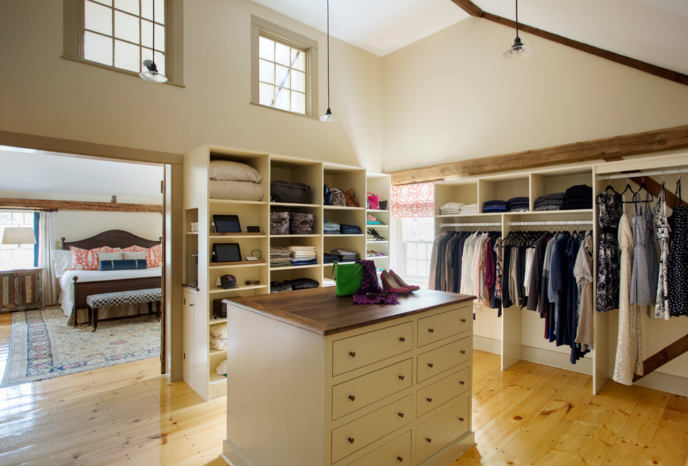 Ejemplo de vestidor unisex de estilo de casa de campo grande con armarios abiertos, puertas de armario beige y suelo de madera clara
