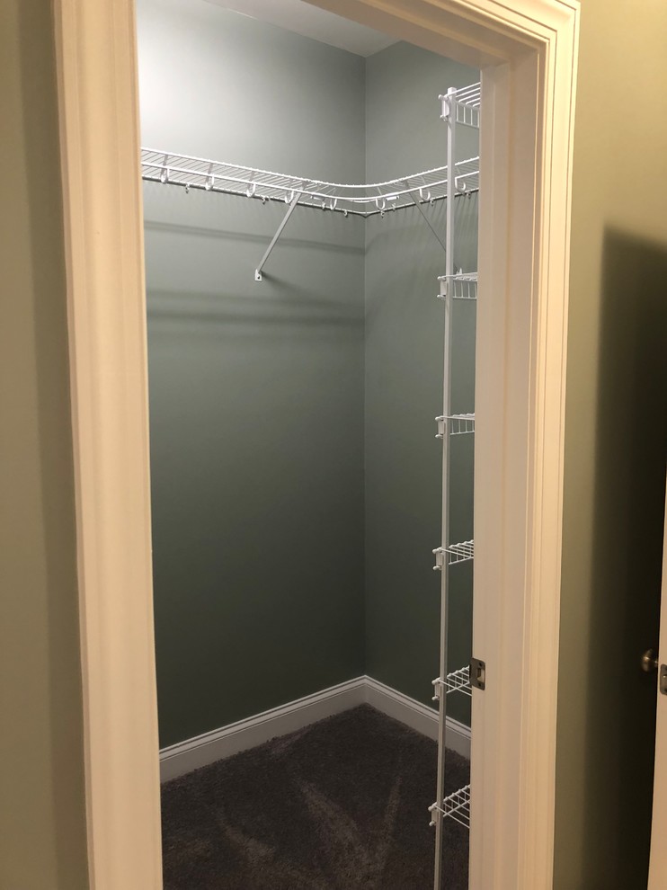 Small traditional gender neutral walk-in wardrobe in Charlotte with carpet and brown floors.