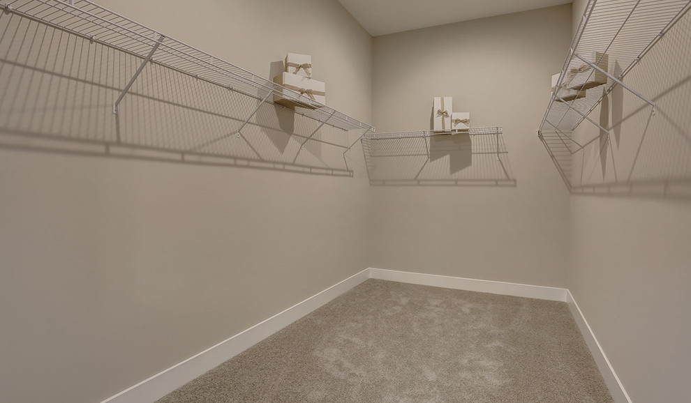 На фото: гардеробная комната среднего размера в стиле кантри с ковровым покрытием и бежевым полом с