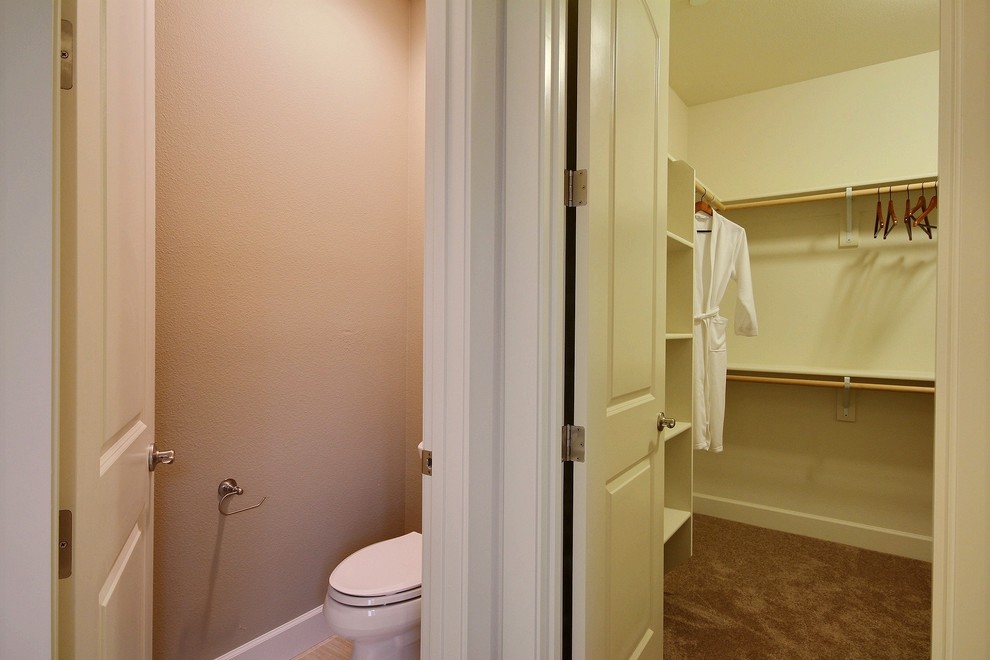 Photo of a large traditional gender neutral walk-in wardrobe in Portland with open cabinets, white cabinets and carpet.