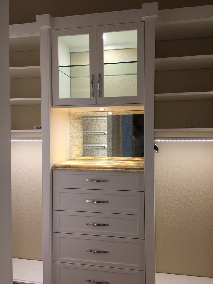 Imagen de armario vestidor unisex tradicional renovado con armarios con paneles lisos, puertas de armario grises y suelo de madera en tonos medios