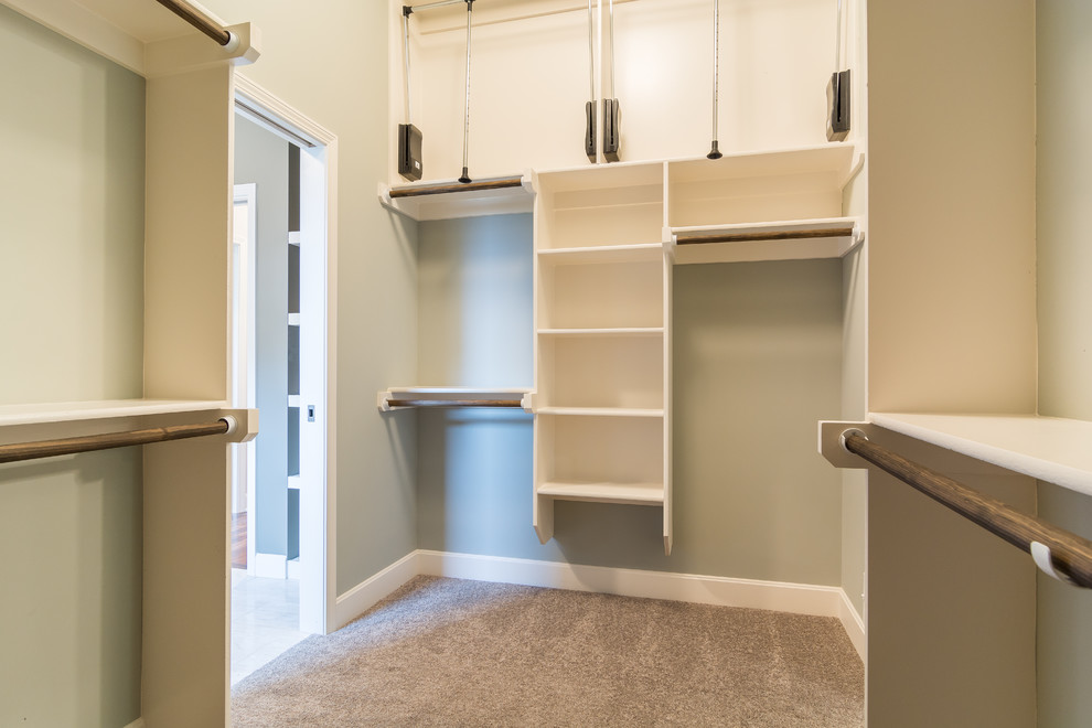 Photo of a medium sized traditional gender neutral walk-in wardrobe in Kansas City with open cabinets, white cabinets and carpet.