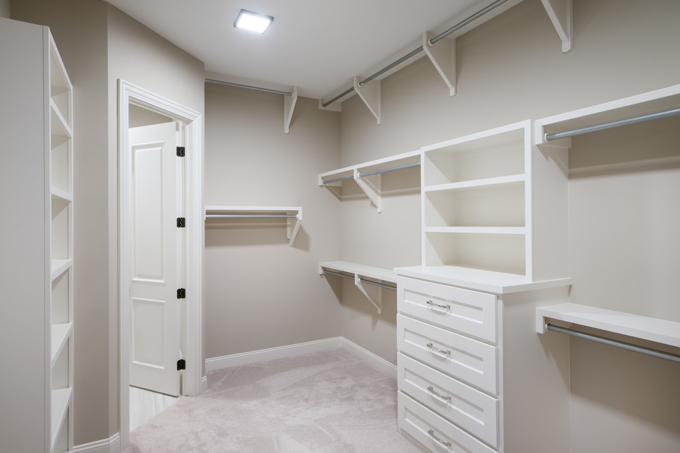 На фото: гардеробная комната среднего размера, унисекс в классическом стиле с фасадами с утопленной филенкой, белыми фасадами, ковровым покрытием и бежевым полом