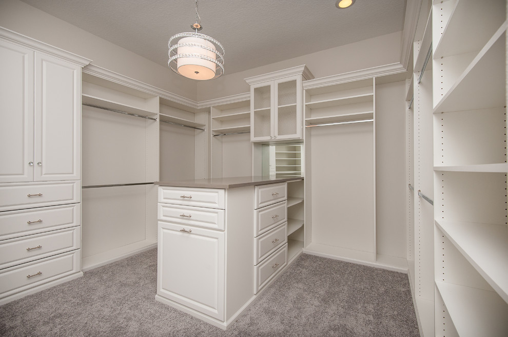 Стильный дизайн: большая гардеробная комната унисекс в стиле неоклассика (современная классика) с белыми фасадами и ковровым покрытием - последний тренд