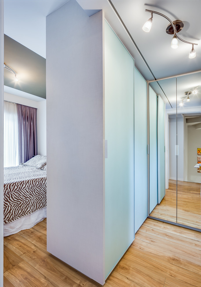 На фото: маленькая гардеробная комната унисекс в современном стиле с стеклянными фасадами и полом из фанеры для на участке и в саду