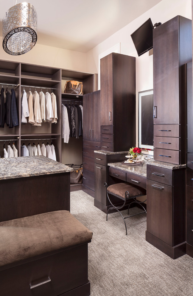 Example of a huge trendy gender-neutral carpeted and gray floor walk-in closet design in Other with flat-panel cabinets and dark wood cabinets