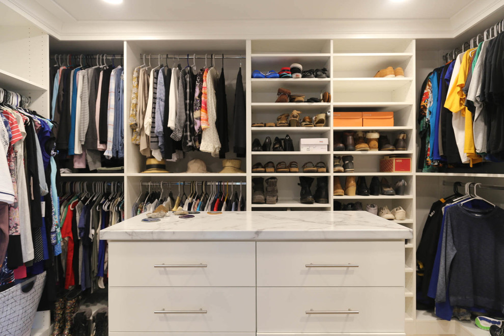 Ejemplo de armario vestidor unisex tradicional renovado de tamaño medio con armarios con paneles lisos, puertas de armario blancas, suelo de madera clara y suelo beige