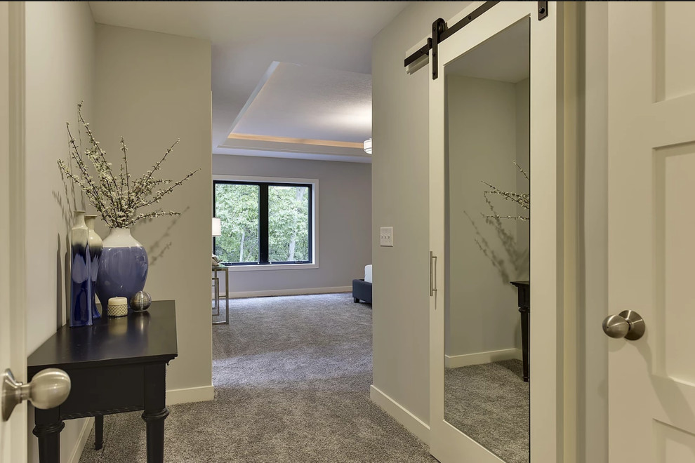 На фото: большая гардеробная комната унисекс в современном стиле с ковровым покрытием с