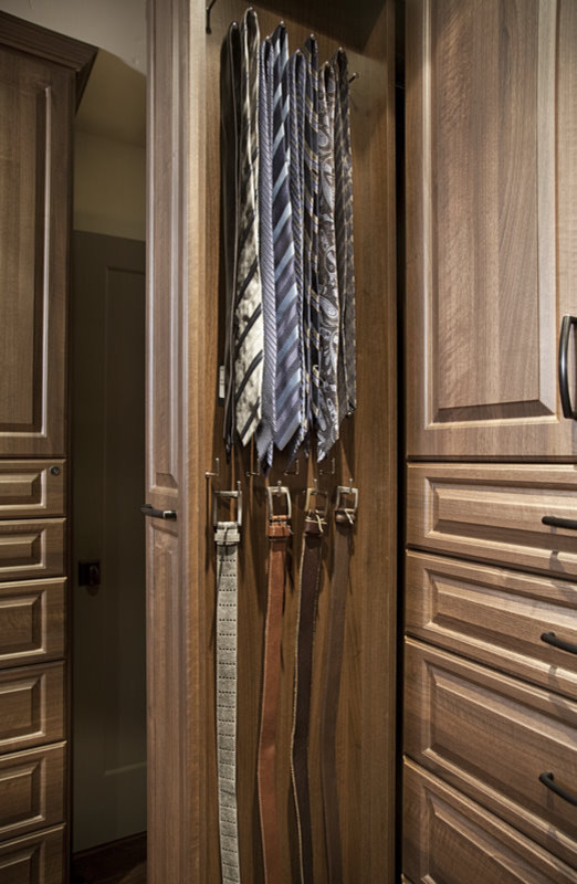 Ejemplo de armario vestidor unisex tradicional de tamaño medio con armarios con paneles con relieve, puertas de armario de madera oscura y suelo de madera oscura