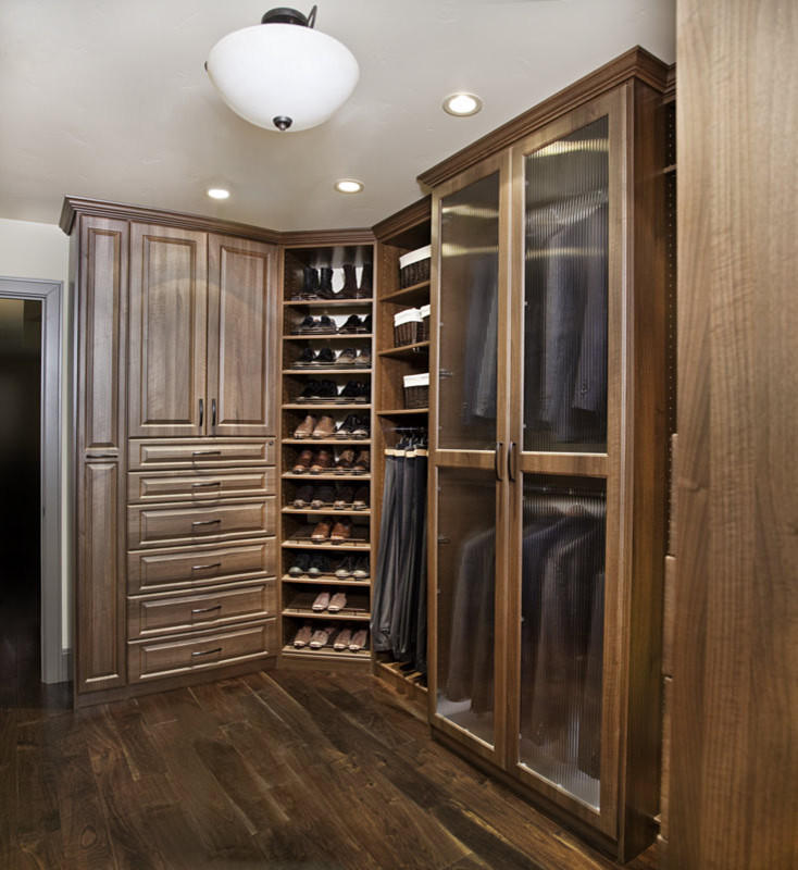 Design ideas for a medium sized traditional gender neutral walk-in wardrobe in San Francisco with raised-panel cabinets, medium wood cabinets and dark hardwood flooring.