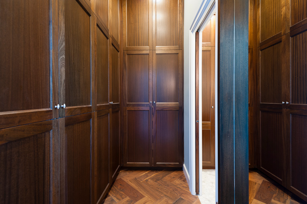 Idee per una piccola cabina armadio per uomo classica con ante in stile shaker, ante in legno bruno e parquet scuro