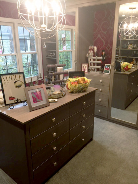 Photo of a large contemporary walk-in wardrobe for women in Chicago with flat-panel cabinets, grey cabinets and carpet.