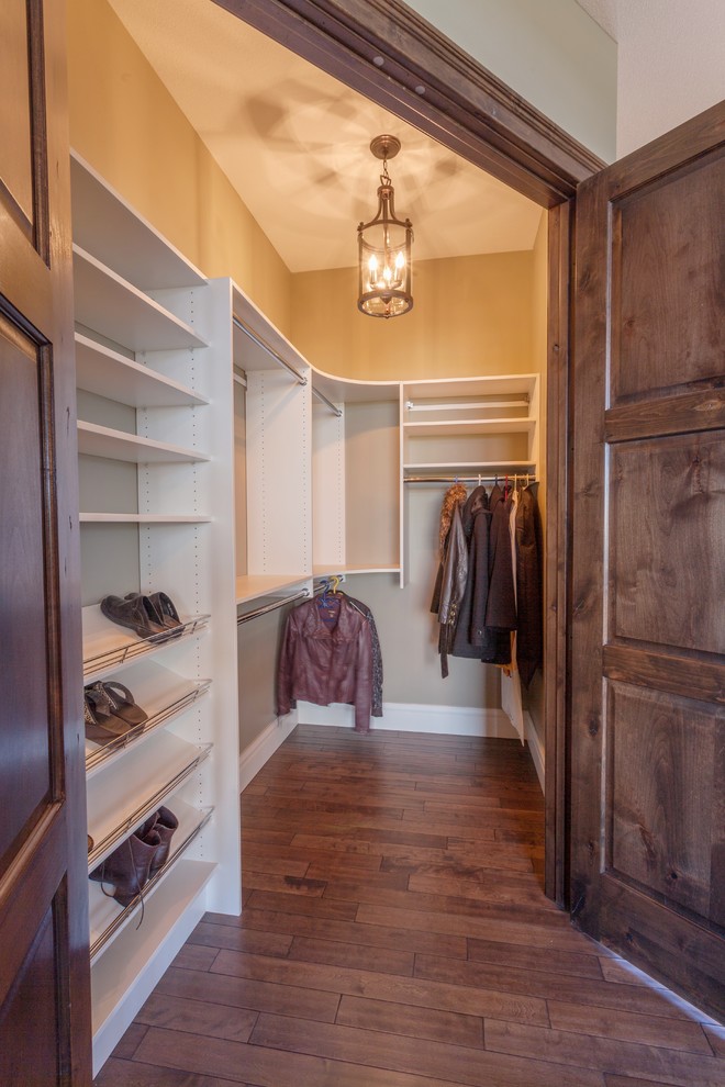 Design ideas for a large classic gender neutral walk-in wardrobe in Calgary with medium hardwood flooring.