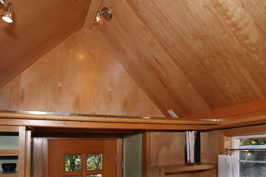 Diseño de armario unisex clásico pequeño con puertas de armario de madera clara y suelo de madera clara