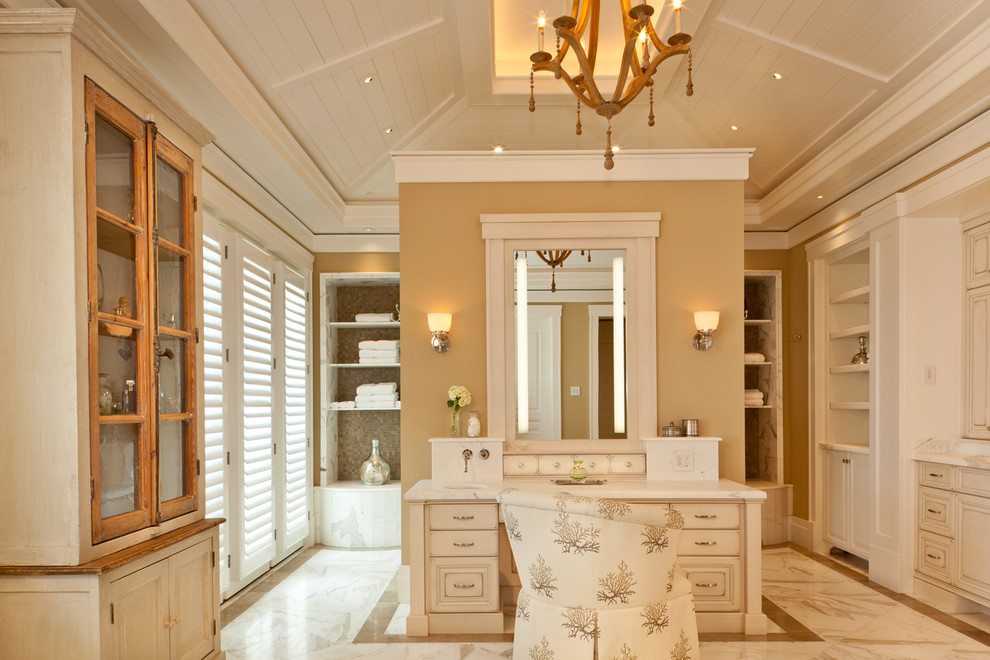 Cette image montre un grand dressing room traditionnel neutre avec un placard avec porte à panneau encastré, des portes de placard blanches et un sol en marbre.