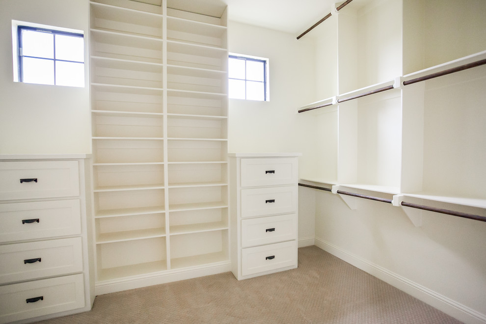 Ejemplo de vestidor unisex clásico grande con armarios estilo shaker, puertas de armario blancas, moqueta y suelo beige