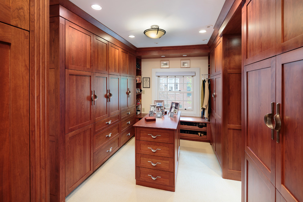 На фото: гардеробная комната в классическом стиле с фасадами в стиле шейкер, фасадами цвета дерева среднего тона и ковровым покрытием с