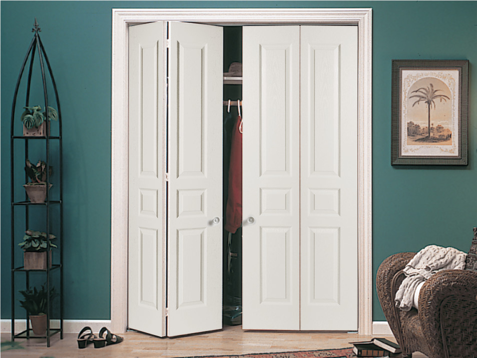 Aménagement d'un petite dressing et rangement classique avec des portes de placard blanches et parquet clair.