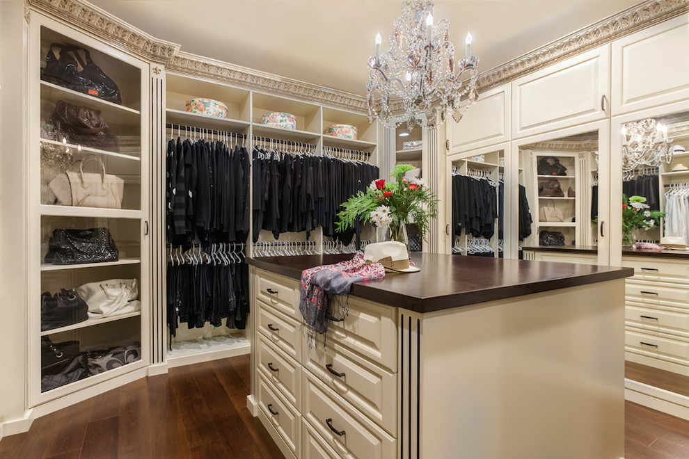 Modelo de armario vestidor unisex tradicional grande con puertas de armario blancas, armarios con paneles con relieve, suelo de madera oscura y suelo marrón
