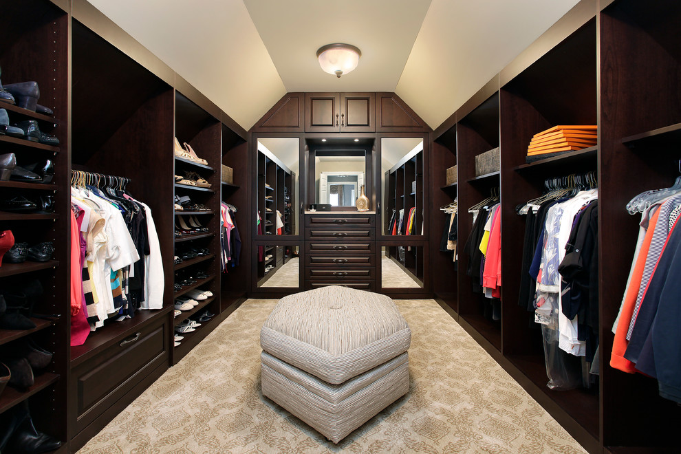 Photo of a traditional walk-in wardrobe in Chicago with dark wood cabinets.