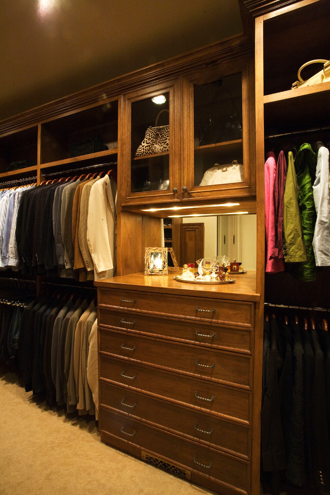 Example of a large classic gender-neutral carpeted walk-in closet design in Dallas with raised-panel cabinets and medium tone wood cabinets