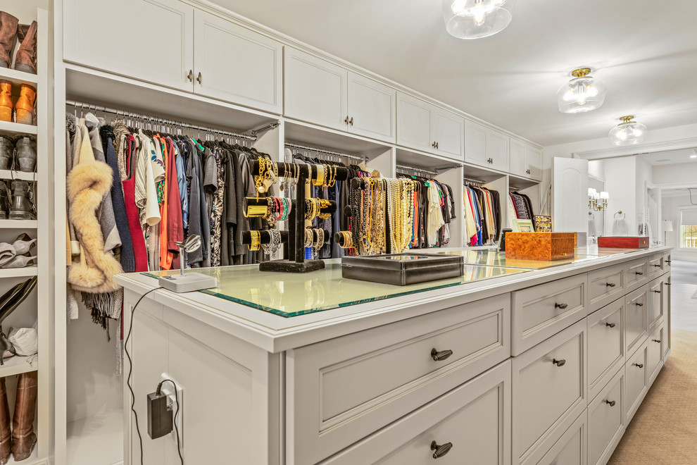 Large classic gender neutral walk-in wardrobe in Cleveland with recessed-panel cabinets, white cabinets, carpet and beige floors.